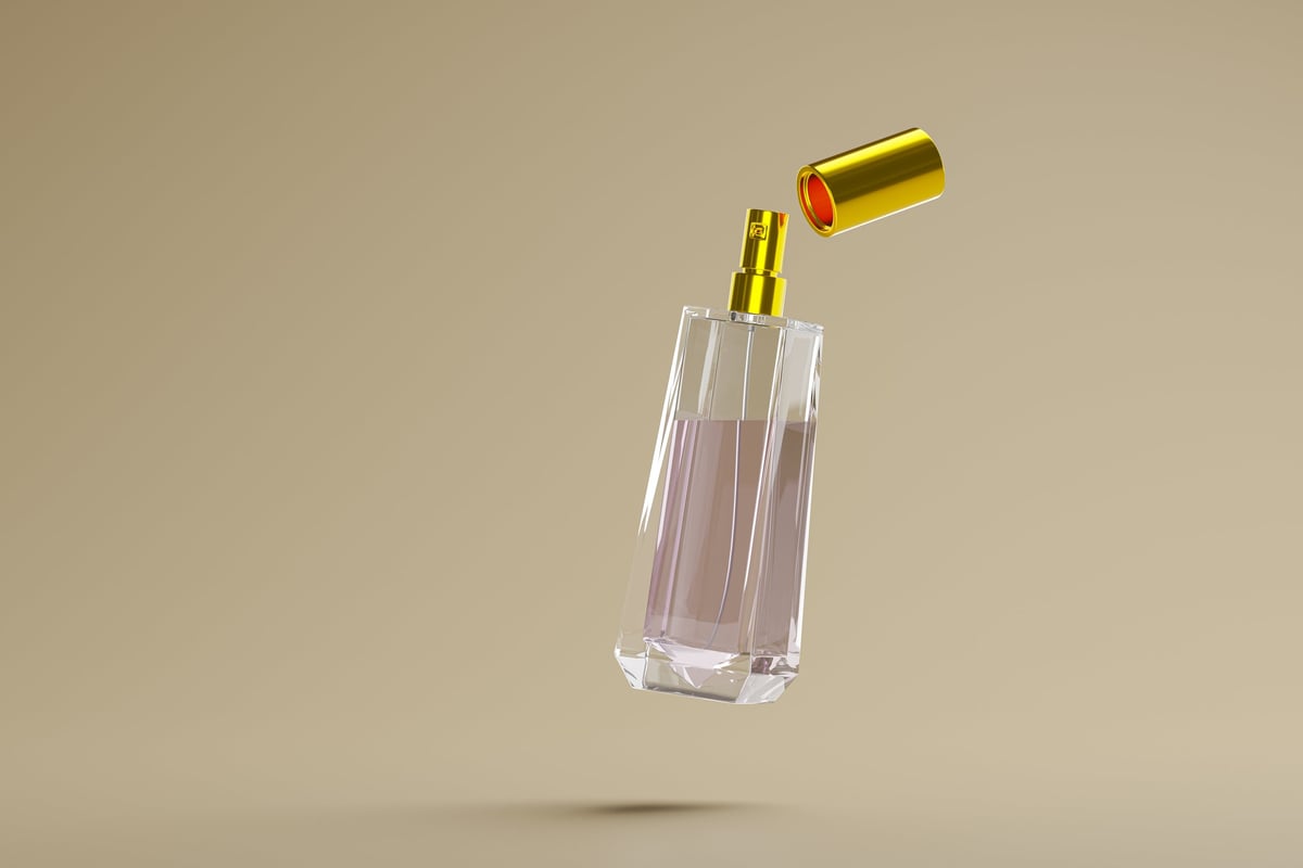 Luxury perfume glass bottle with a floating gold cap on beige background