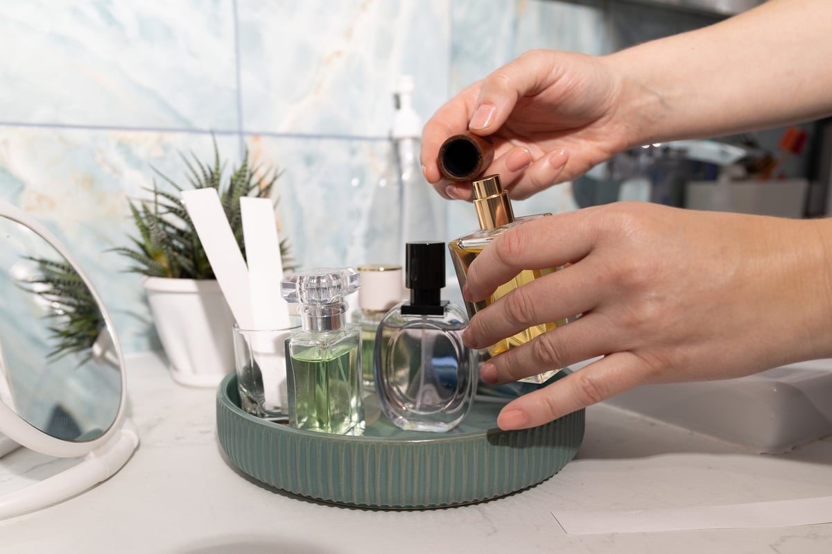 Glass perfume bottle with gold spray top on marble vanity